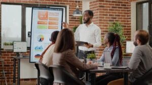 company-employee-presenting-business-strategy-with-charts-monitor-planning-project-workmates-analyzing-financial-statistics-display-working-together-company-skills-development-create-infinity-2023
